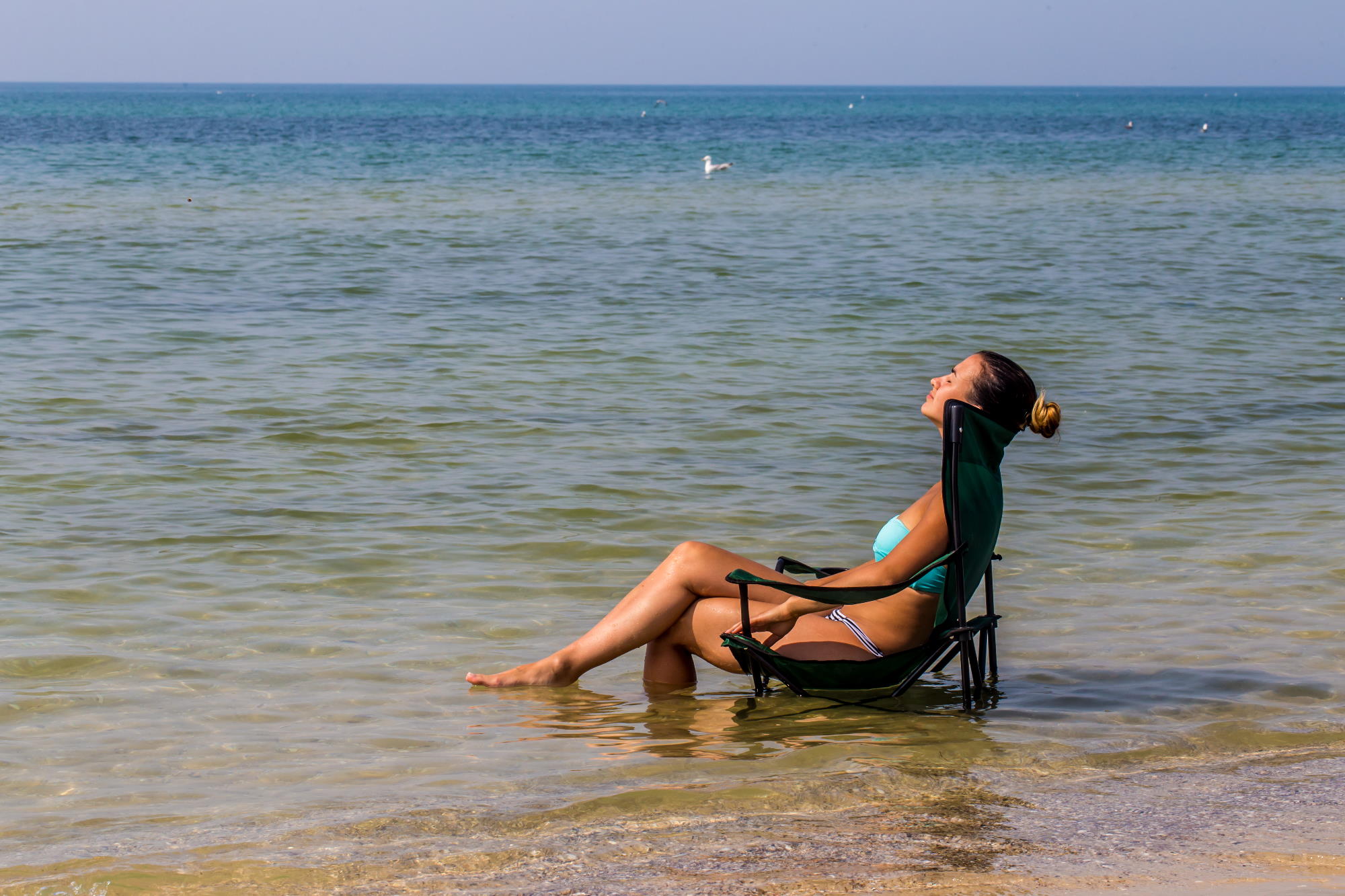 beautiful girl sits alone in the sea, nice tan mujer-sentada-en-playa